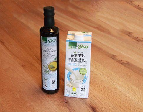 Nah und Gut Haible - Veganer Lebensmittel von Edeka - Bildinhalt: Getränkekarton befüllt mit veganem Haferdrink von laktosefreier und kontrolliert ökologischer Landwirtschaft sowie Bio Olivenöl in einer braunen Flasche.